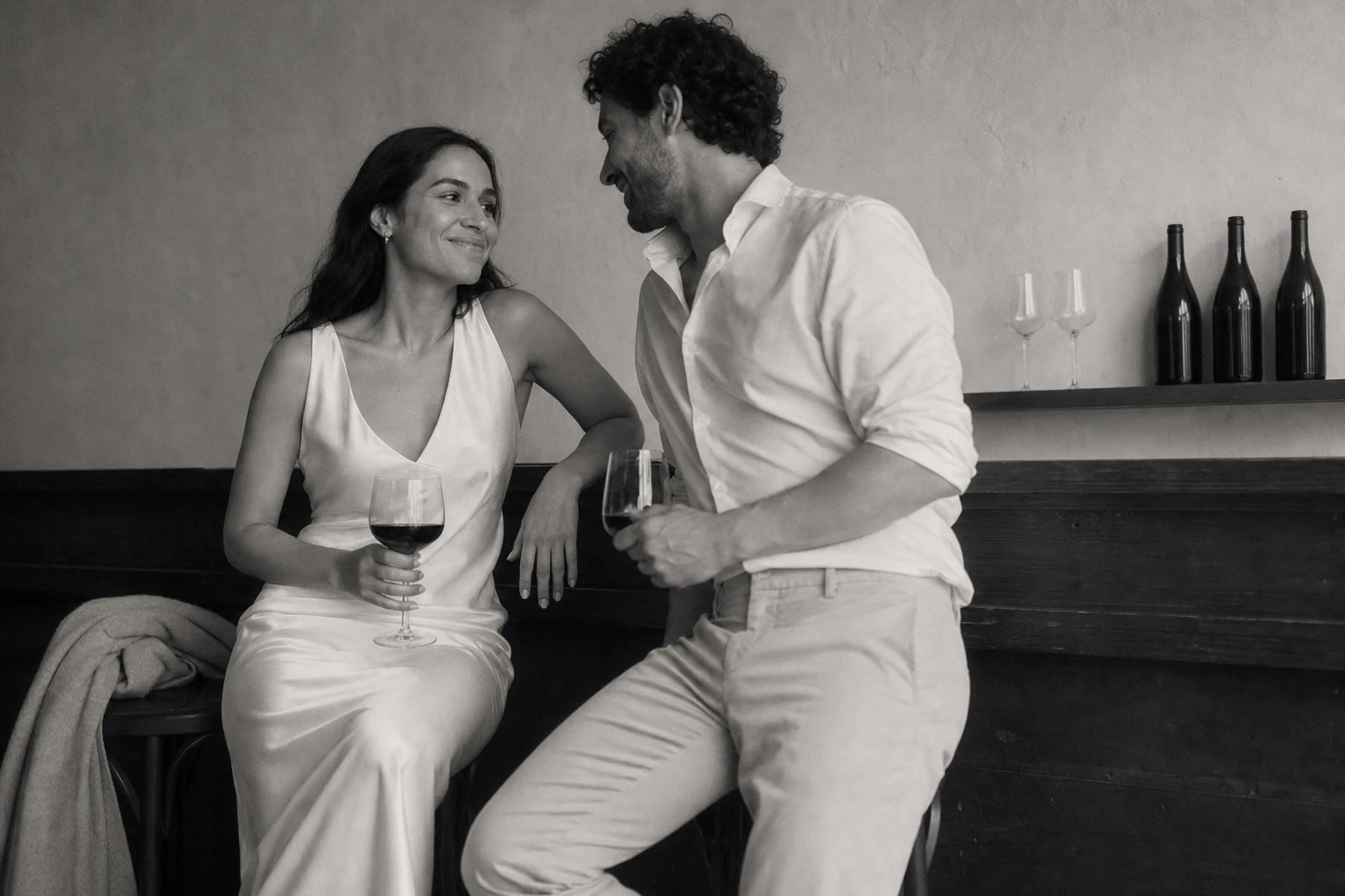 Pareja joven compartiendo una conversación y una copa en un momento íntimo antes de la celebración