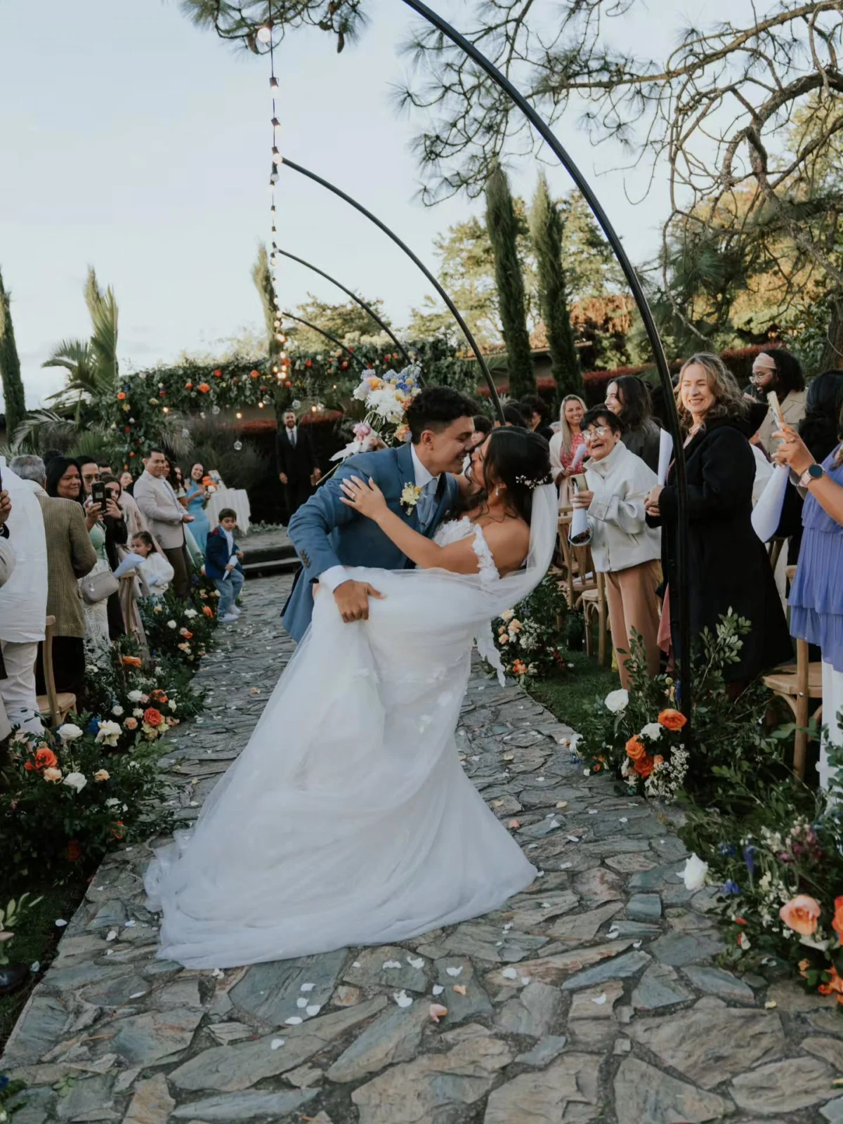 Pareja celebrando su boda al aire libre, con montañas y un lago al fondo.